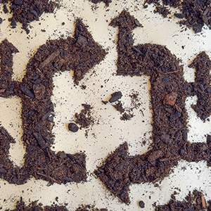 Dirt arranged in the shape of arrows pointing in a circle.