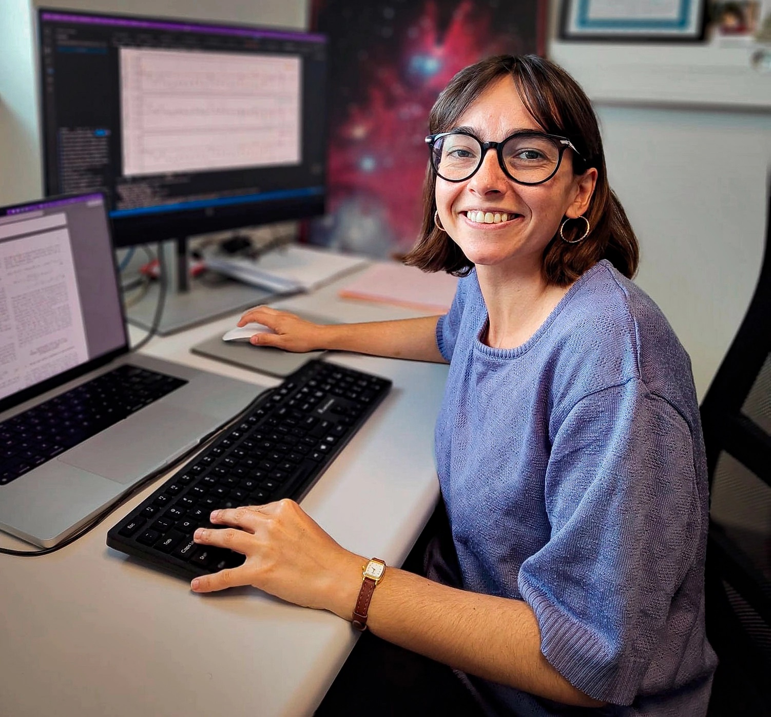 A woman sits at a computer.