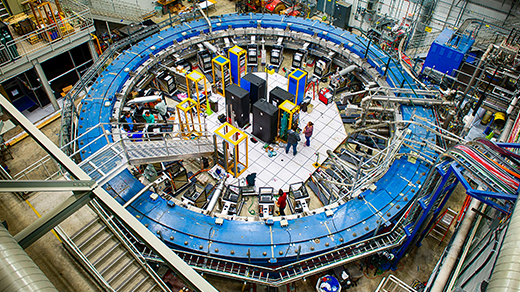 A blue magnetic ring nearly fills a warehouse-sized laboratory.