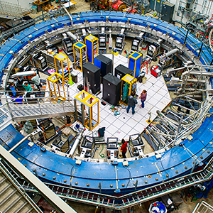 A blue magnetic ring nearly fills a warehouse-sized laboratory.