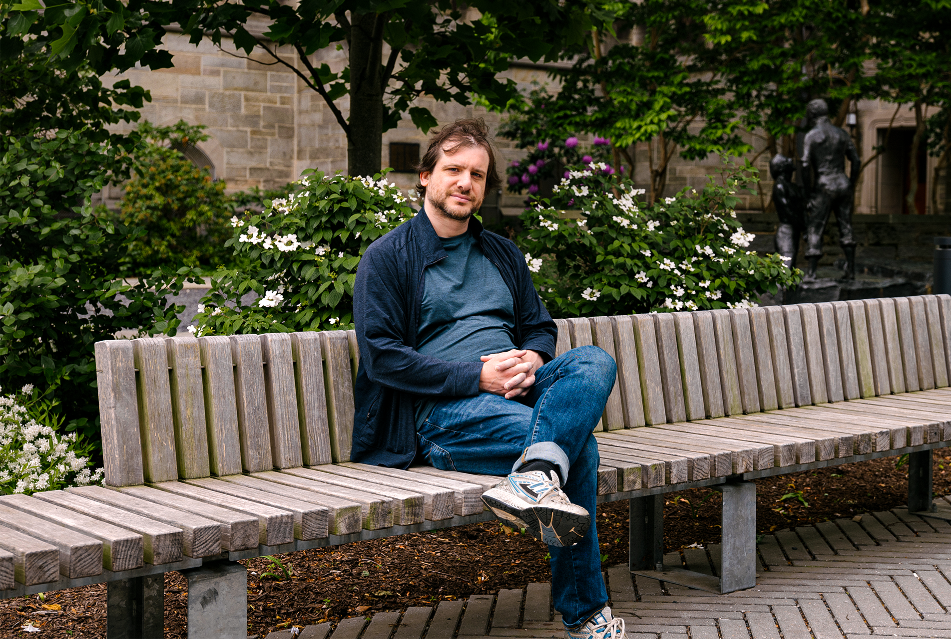 A man sitting on a bench outside.