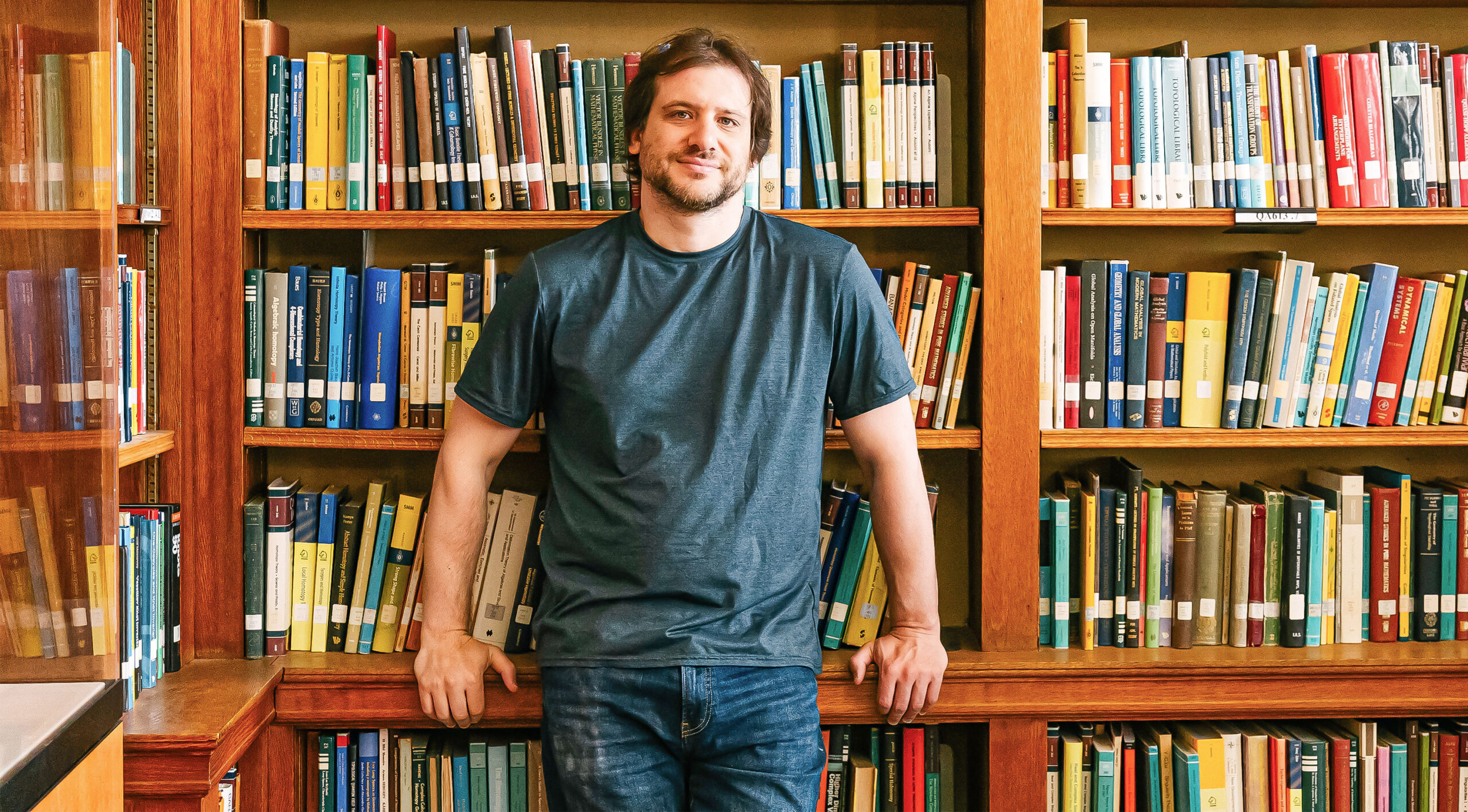 A man in front of books at library.