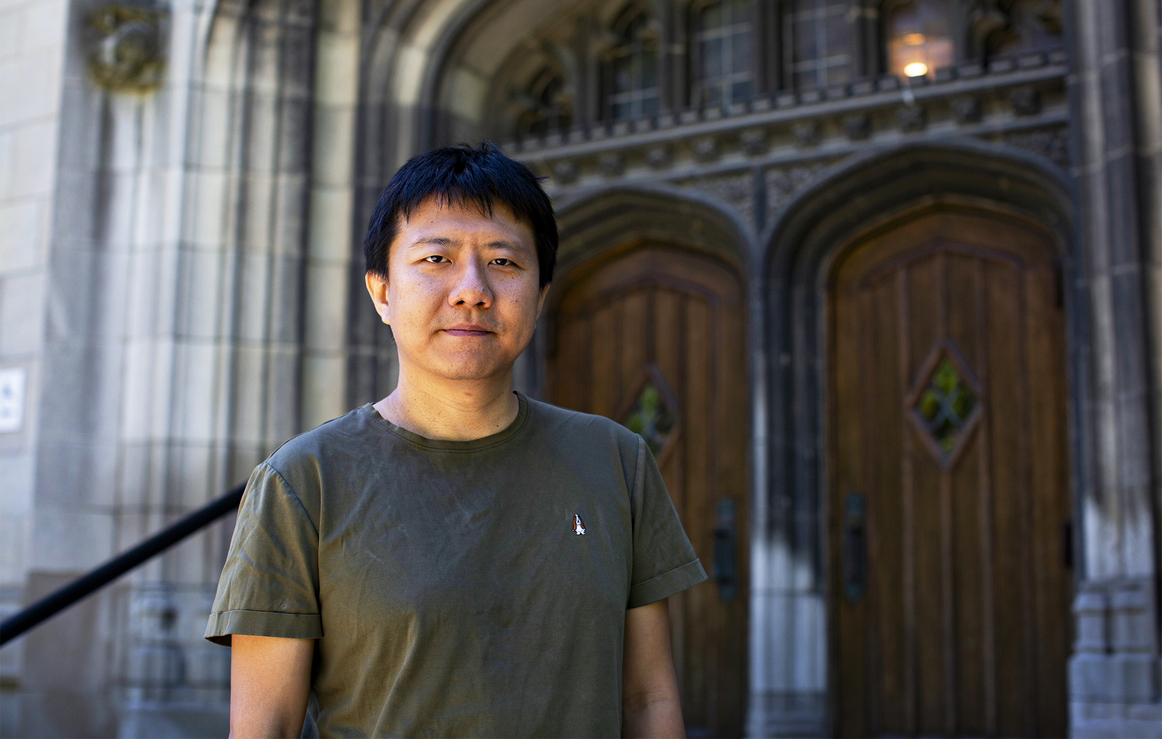 A man in front of large cathedral-like doors.