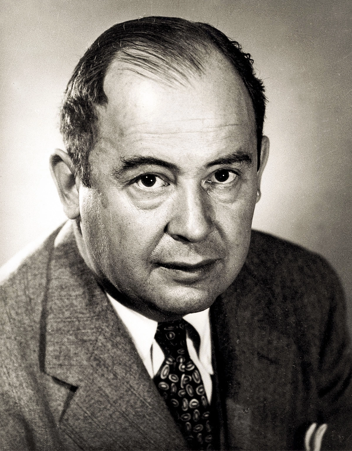 A man sits wearing a suit and tie.