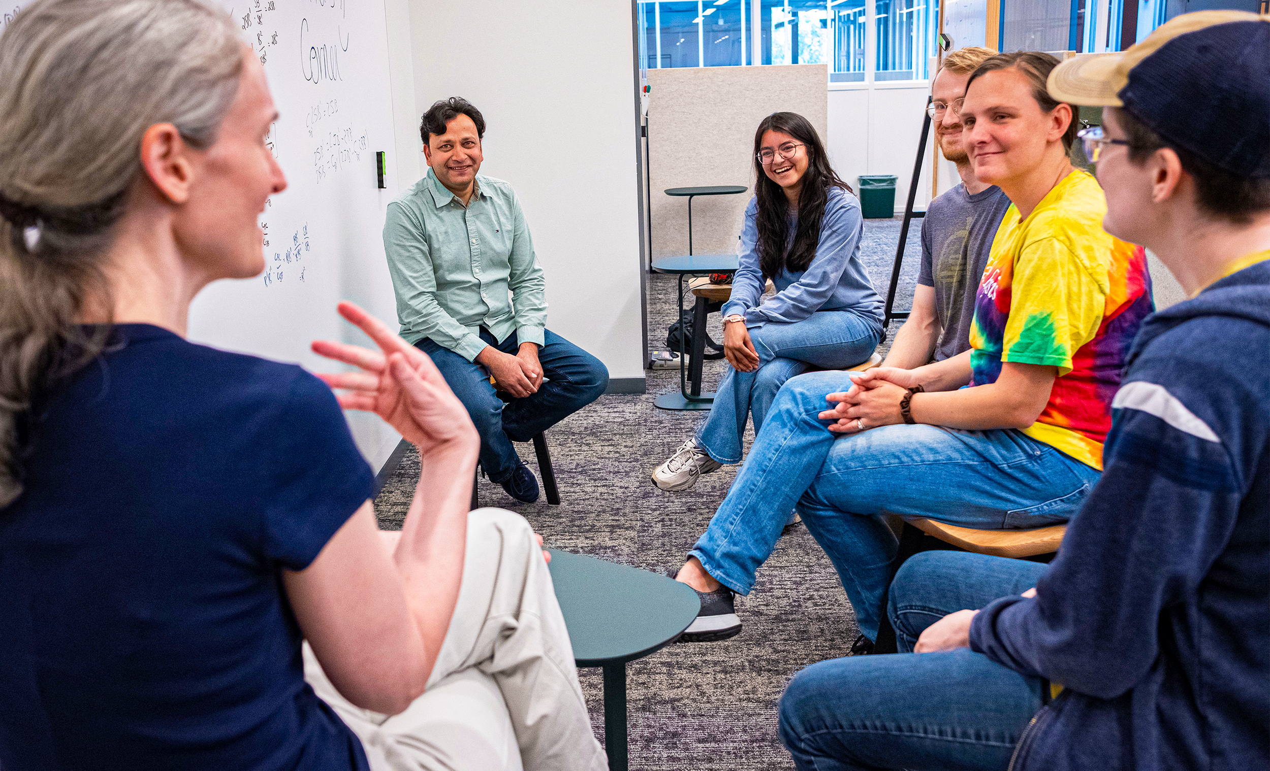 Demers sits and talks with a group of people at Yale.