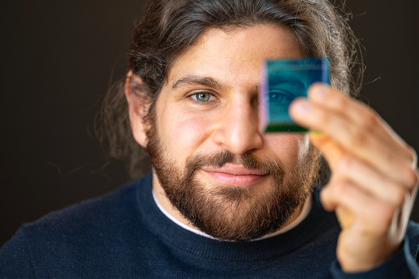 Man holding up a translucent cube.