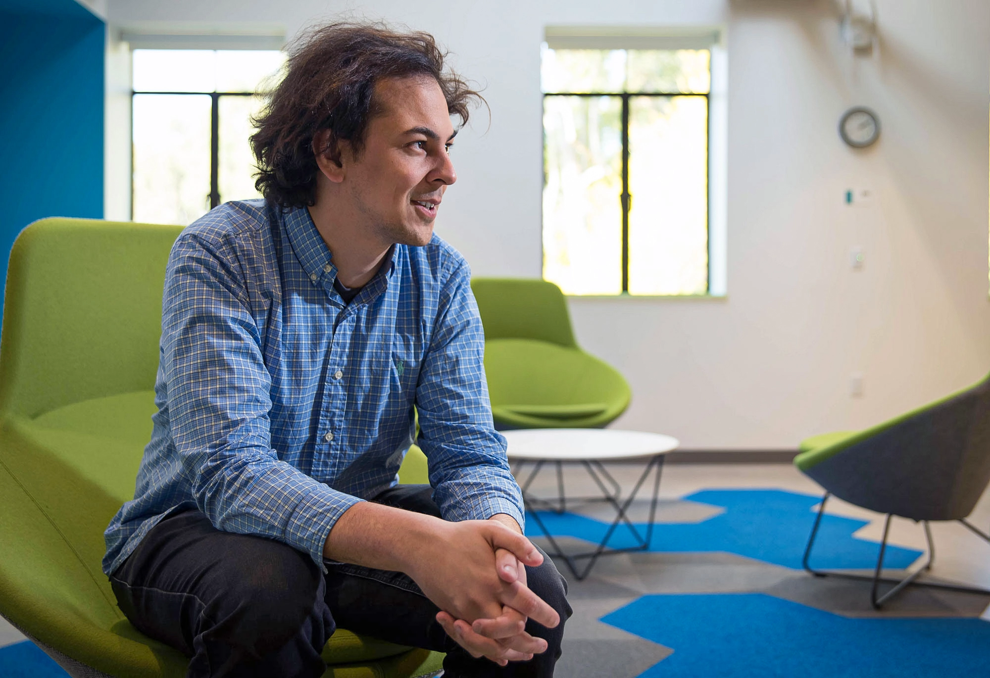 Man sitting in a chair, smiling.