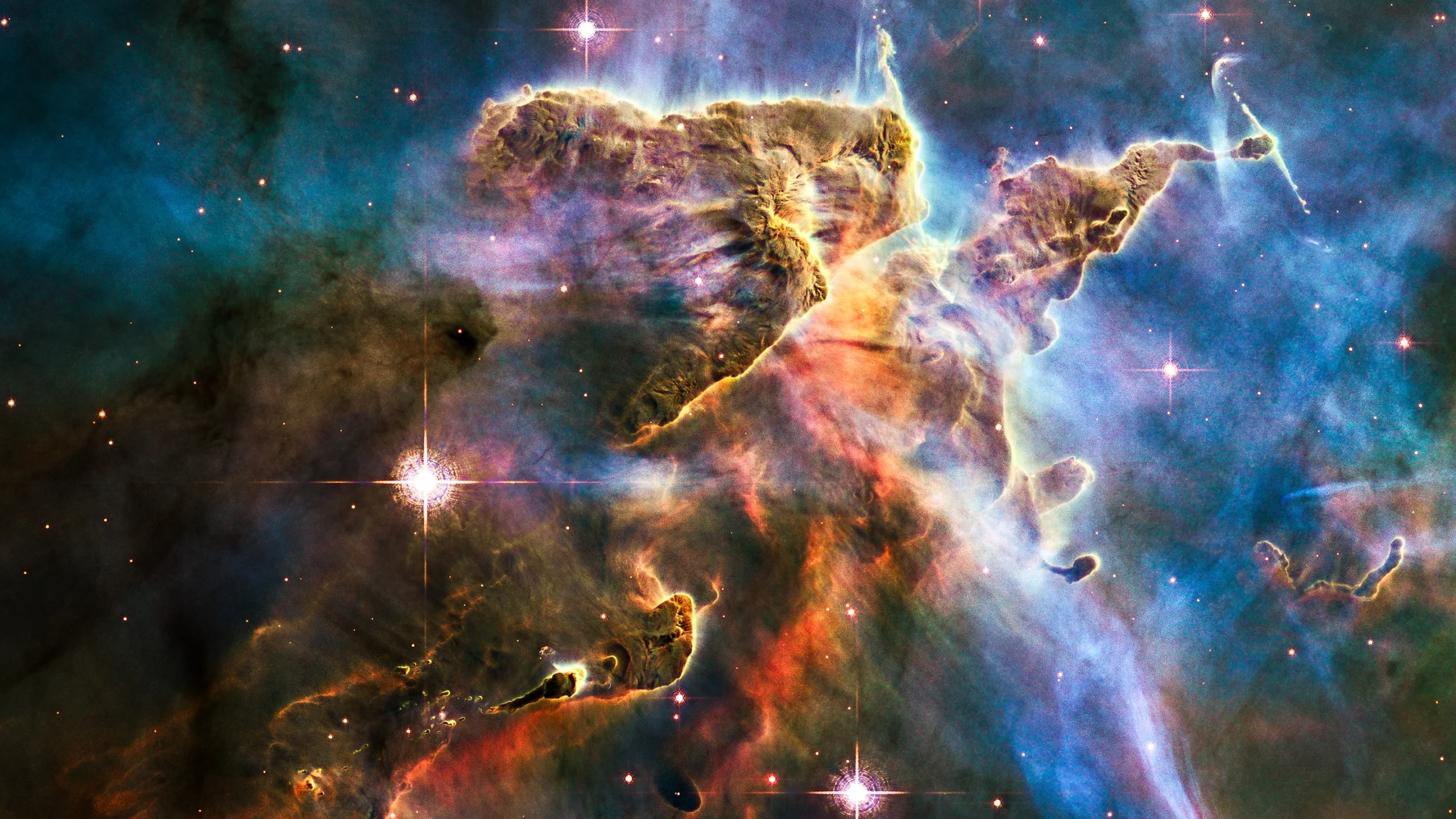 Clouds of dust, in browns and reds and bordered by whisps of blues and purples, shimmer against a backdrop dotted with stars.
