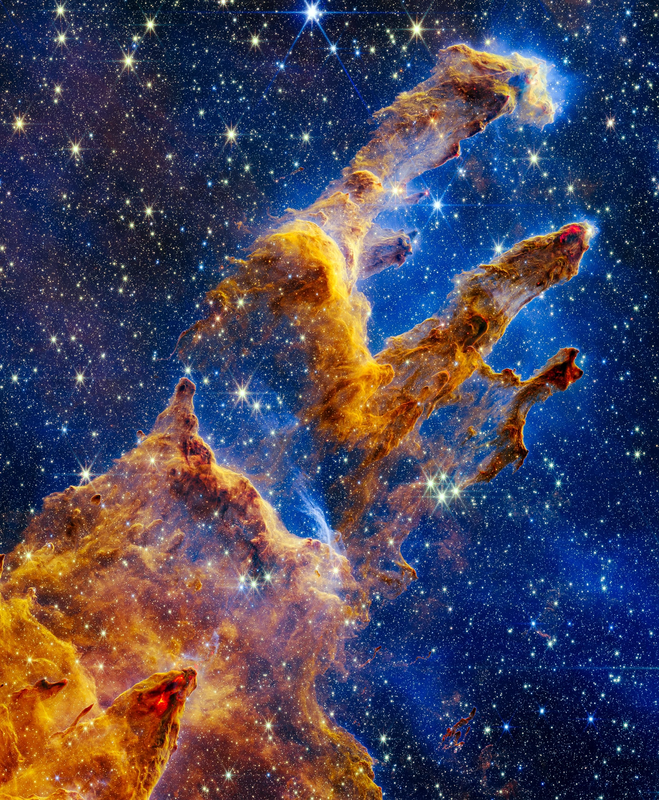 Three enormous smoke-like spires of dust stretch across an expanse of space.