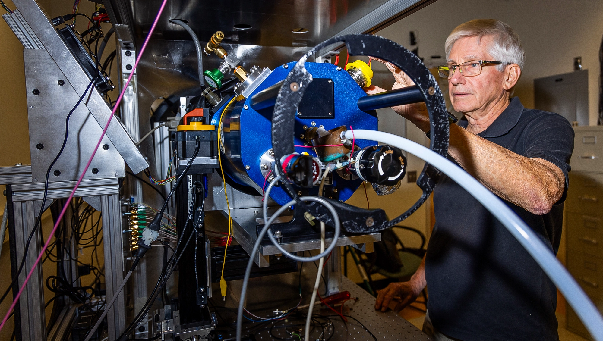 A man standing next to a large piece of lab equipment.