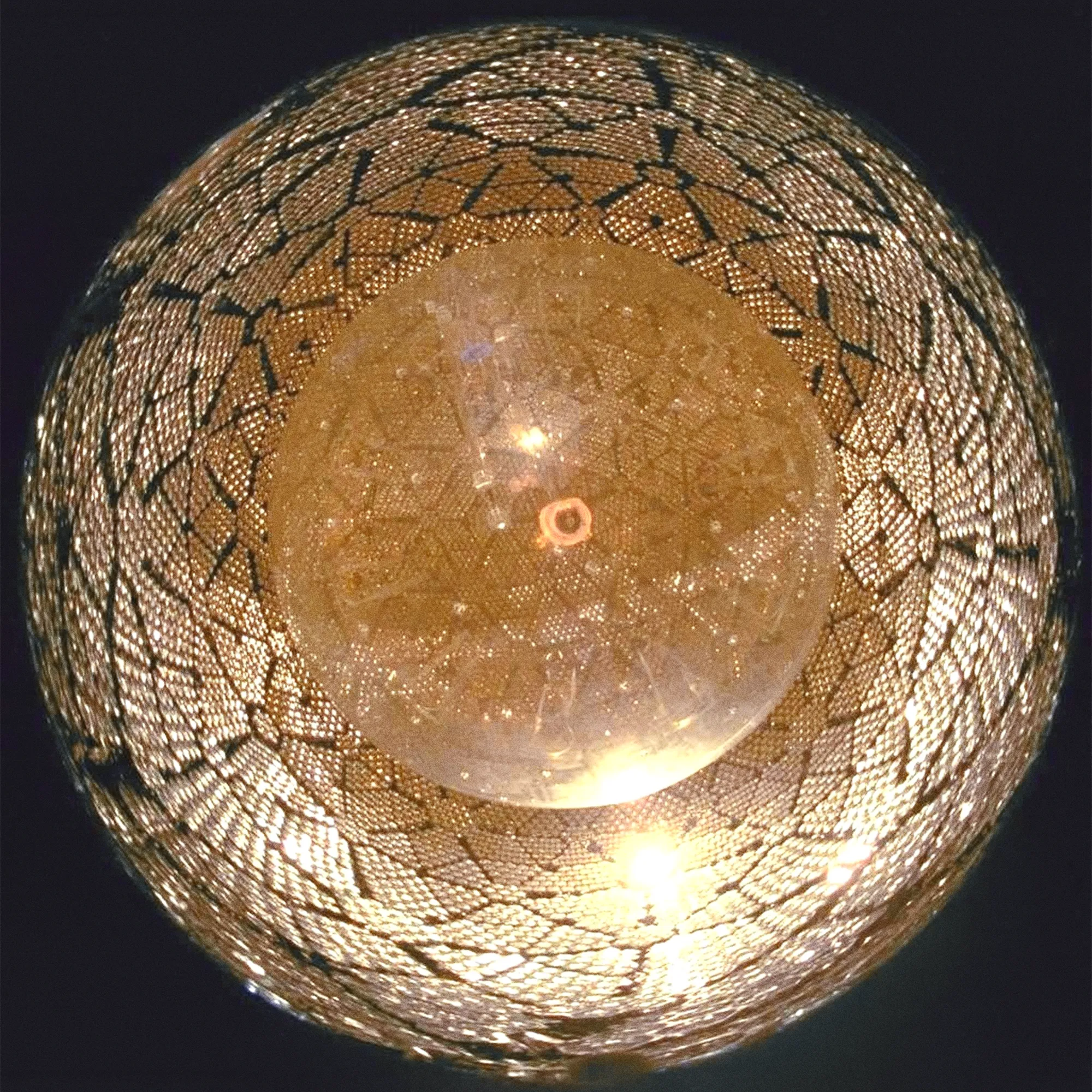 Fisheye photograph looking upward from inside a large sphere showing a transparent inner vessel.